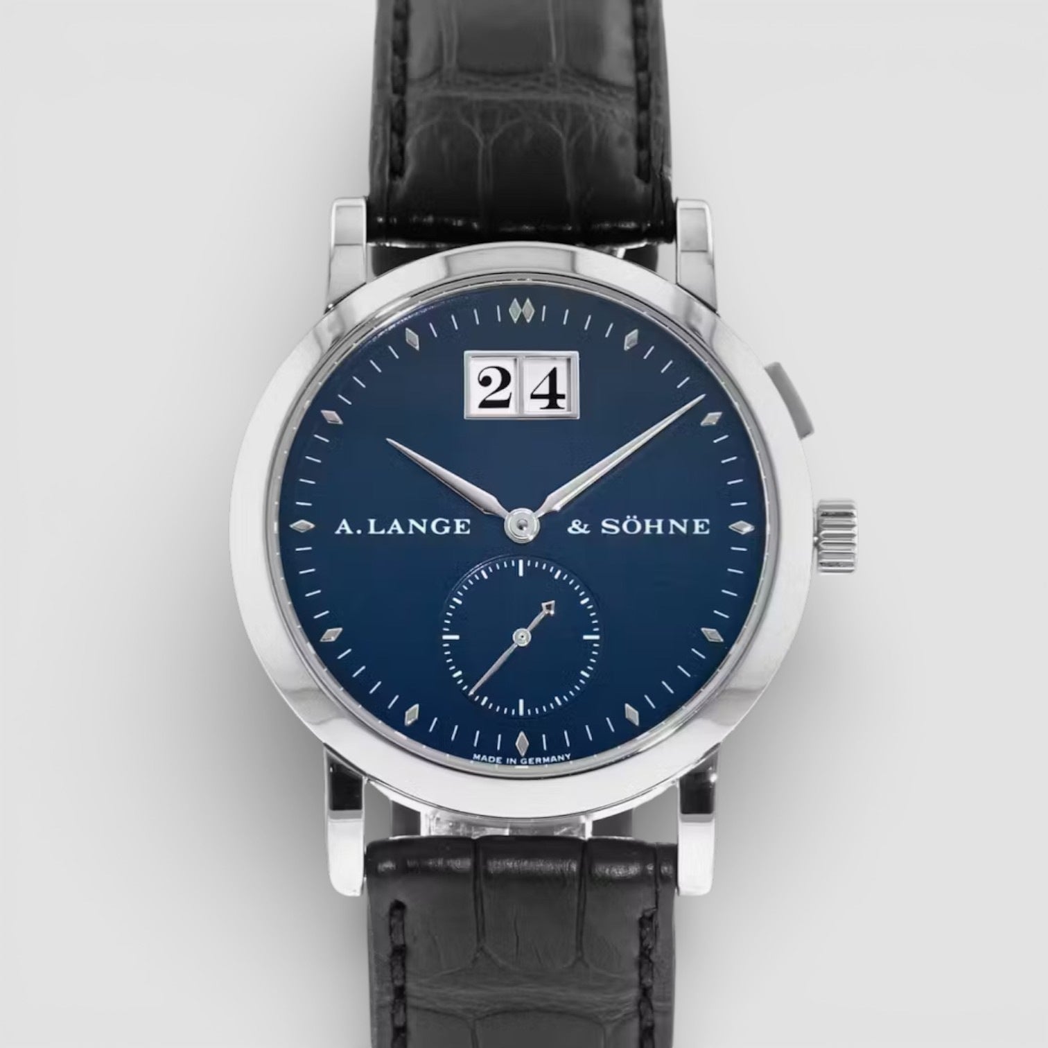 Watch with blue dial and black leather strap on a white background