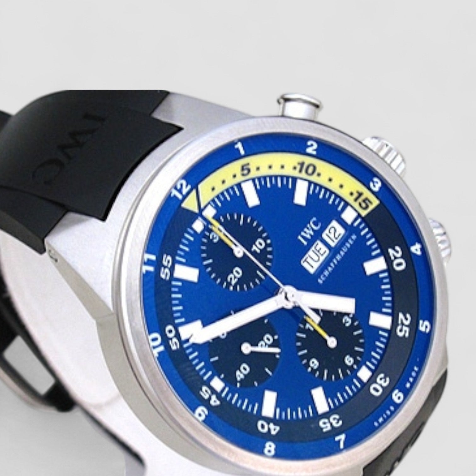 Wristwatch with blue dial and black strap on a light gray background
