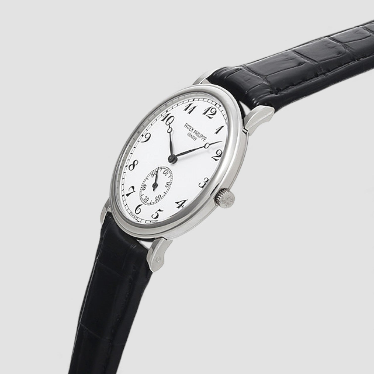 Patek Philippe luxuary Watch with black leather strap and white face on a light gray background