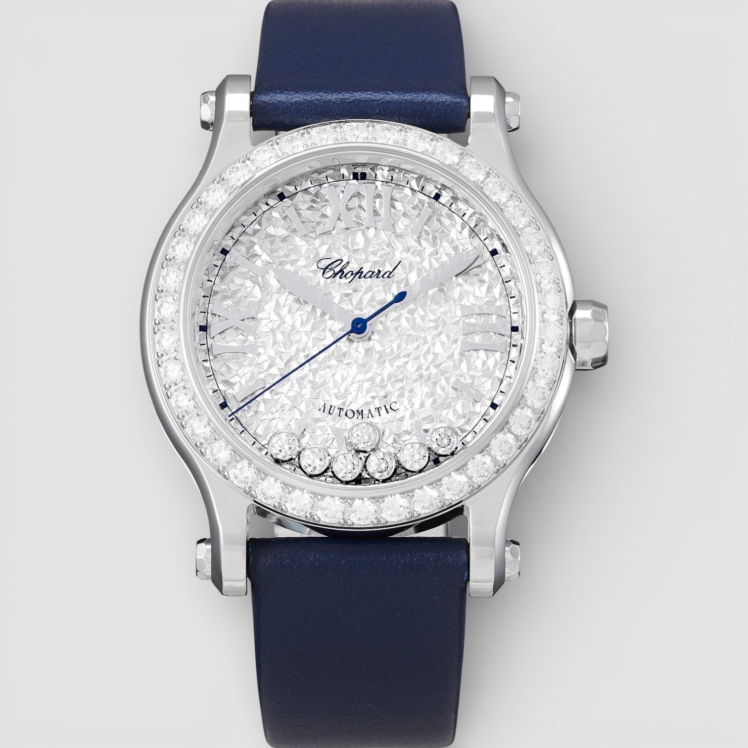 Chopard watch with blue strap and diamond-studded face on a light gray background