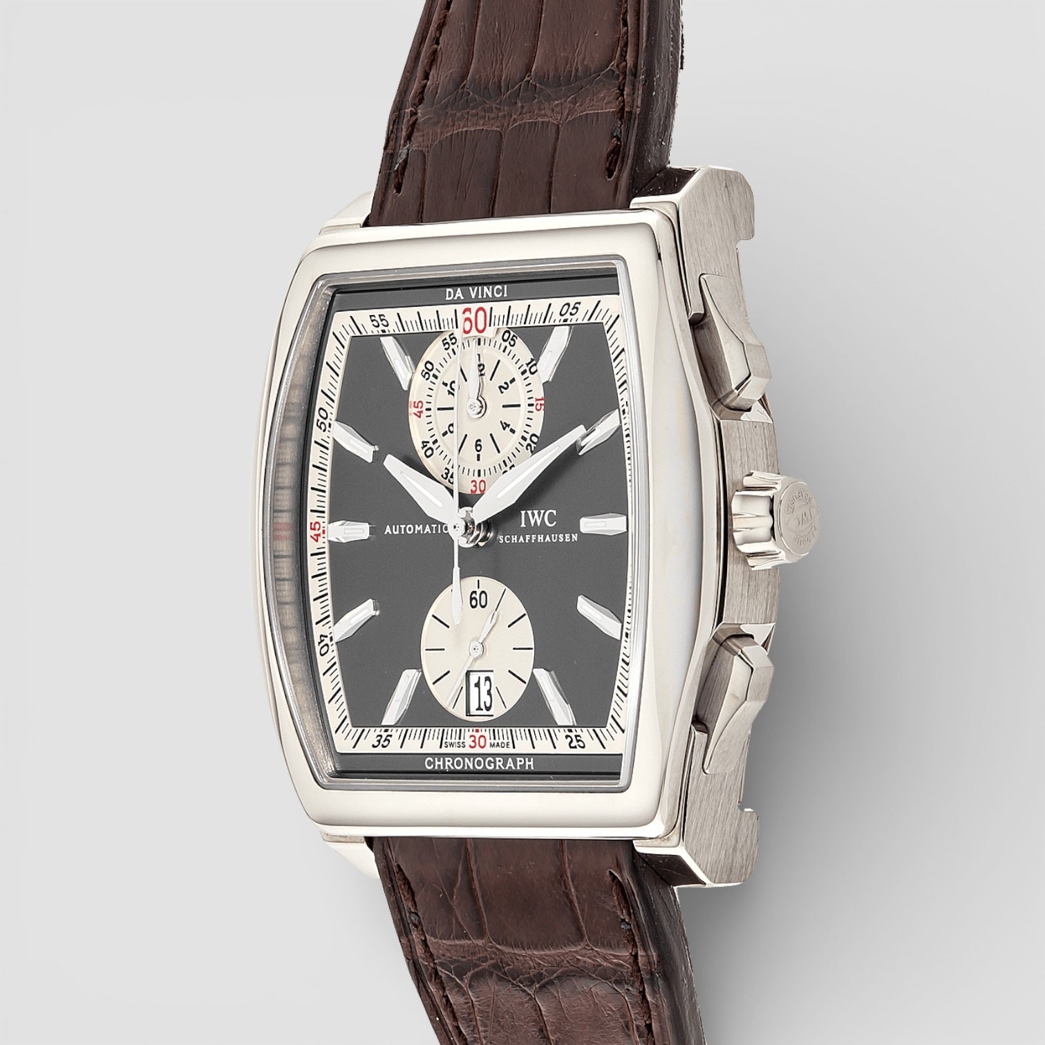 Luxury watch with brown leather strap and silver case on a light gray background